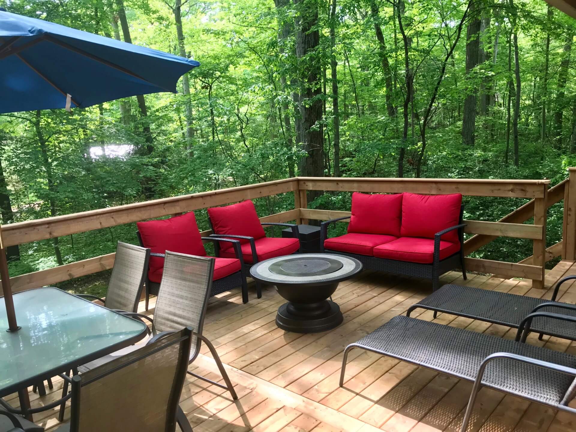 Large private deck with outdoor seating, fire pit table and surrounding trees